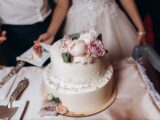 Tarta de boda de doble altura decorada con flores en tonos pastel.