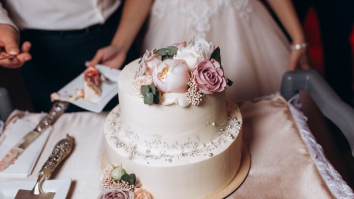Tarta de boda de doble altura decorada con flores en tonos pastel.